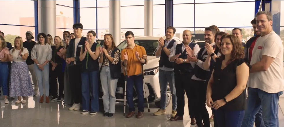 Grupo de colaboradores reunidos num espaço interior amplo, em contexto de encontro.