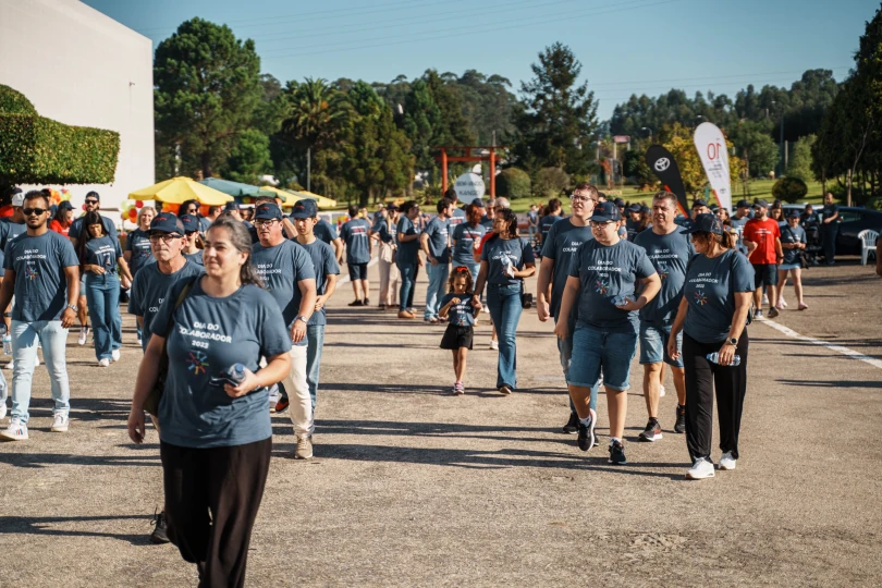 Grupo de colaboradores a caminhar num espaço exterior, em contexto de evento.