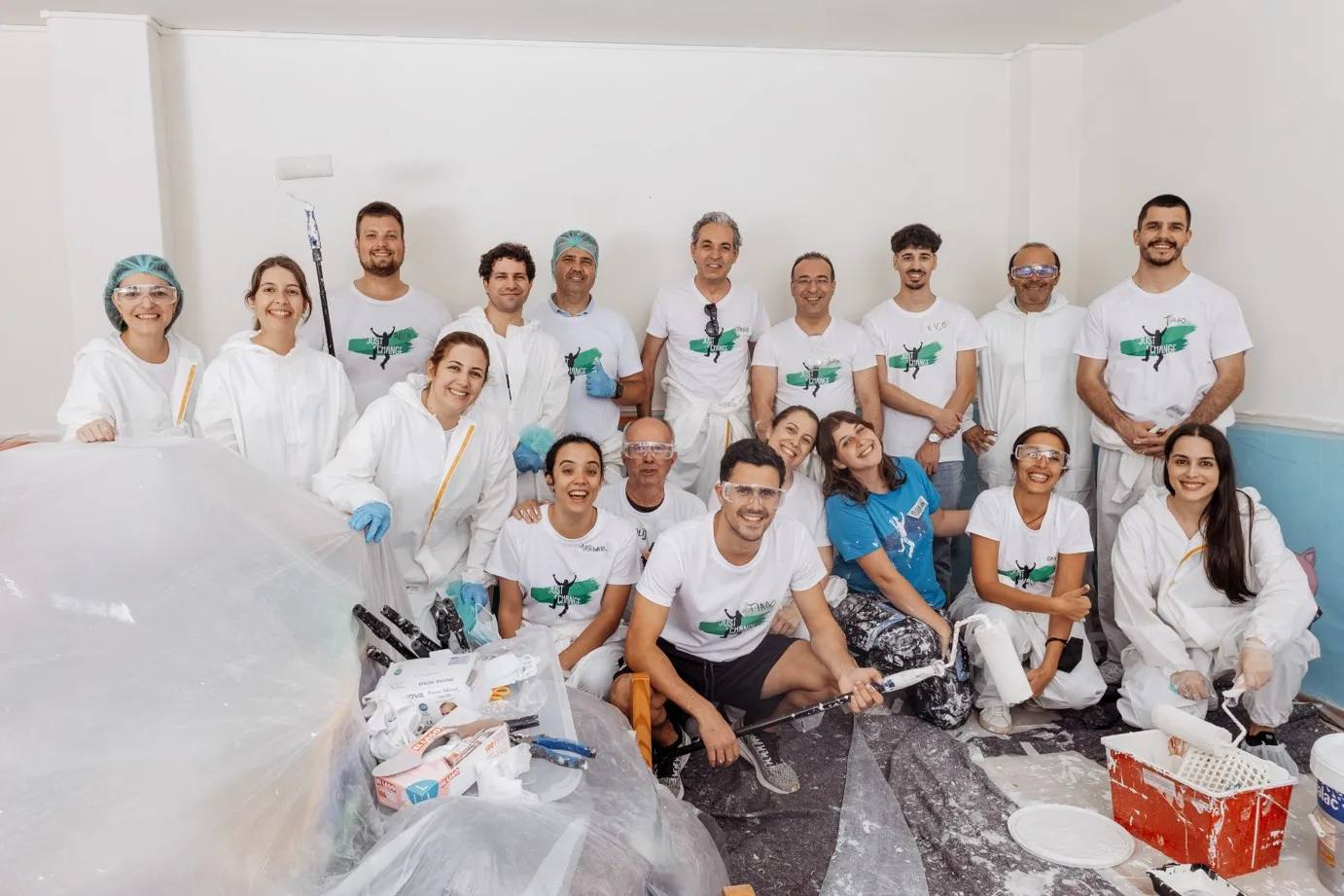 Grupo de colaboradores reunidos num espaço interior, em contexto de atividade de voluntariado.