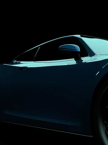 Detalhe de um automóvel moderno visto de perfil, com iluminação baixa e fundo escuro.