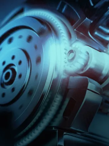 Detalhe de um equipamento industrial, com componentes mecânicos em destaque e iluminação técnica.