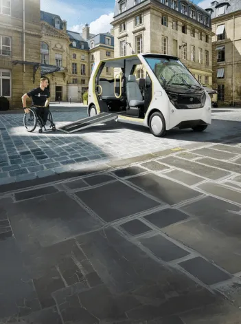 Veículo de mobilidade urbana para pessoas com mobilidade reduzida a circular numa zona histórica da cidade, em ambiente urbano.