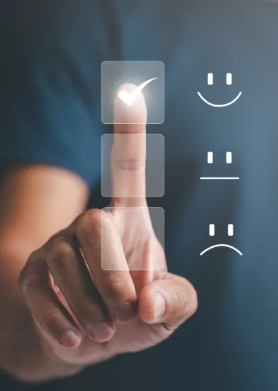 Uma mão a tocar num ecrã tátil que apresenta uma escala de satisfação, com um cursor a selecionar a opção de cara sorridente, indicando uma experiência positiva.