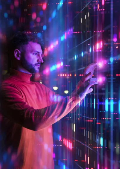 Um homem de perfil a interagir com um ecrã digital com dados em gráficos e listas, rodeado por luzes brilhantes e cores neon.